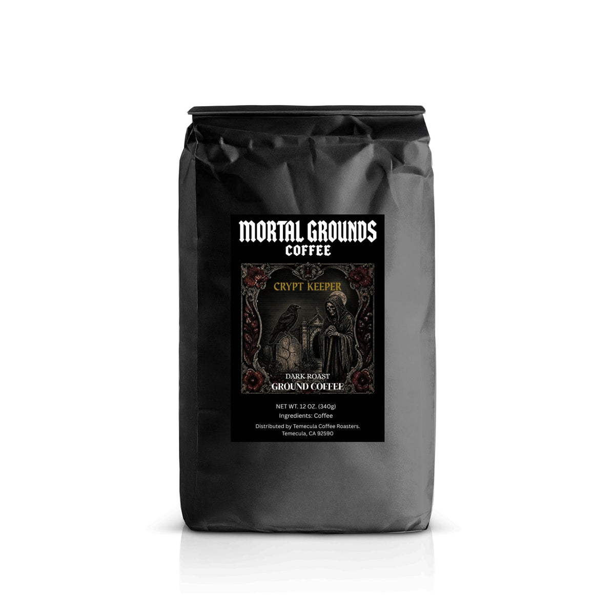 A black bag of Mortal Grounds Coffee, Crypt Keeper, Dark Roast Ground Coffee, standing upright on a white background with a subtle reflection.