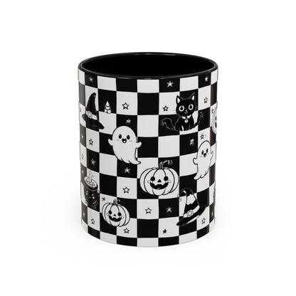 A cylindrical ceramic mug with a black and white checkerboard pattern decorated with cute Halloween illustrations, including ghosts, pumpkins, a cat, a witch hat, and stars. The mug is shown on a clean white background.