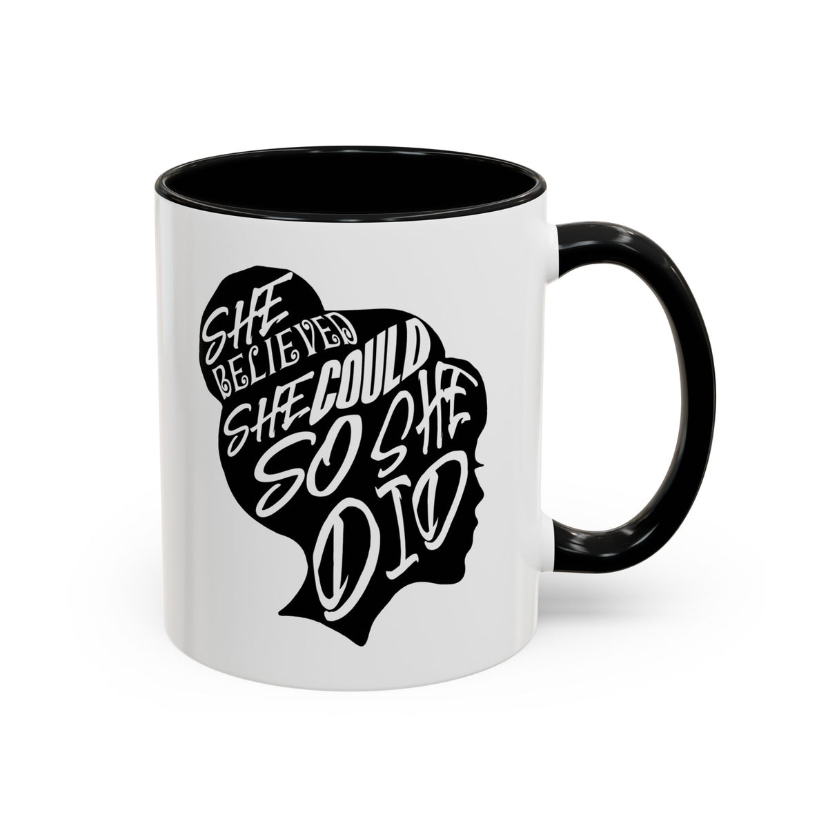 A white ceramic mug with a black interior, black handle, and a black graphic of a woman's profile containing the text 'SHE BELIEVED SHE COULD SO SHE DID'.